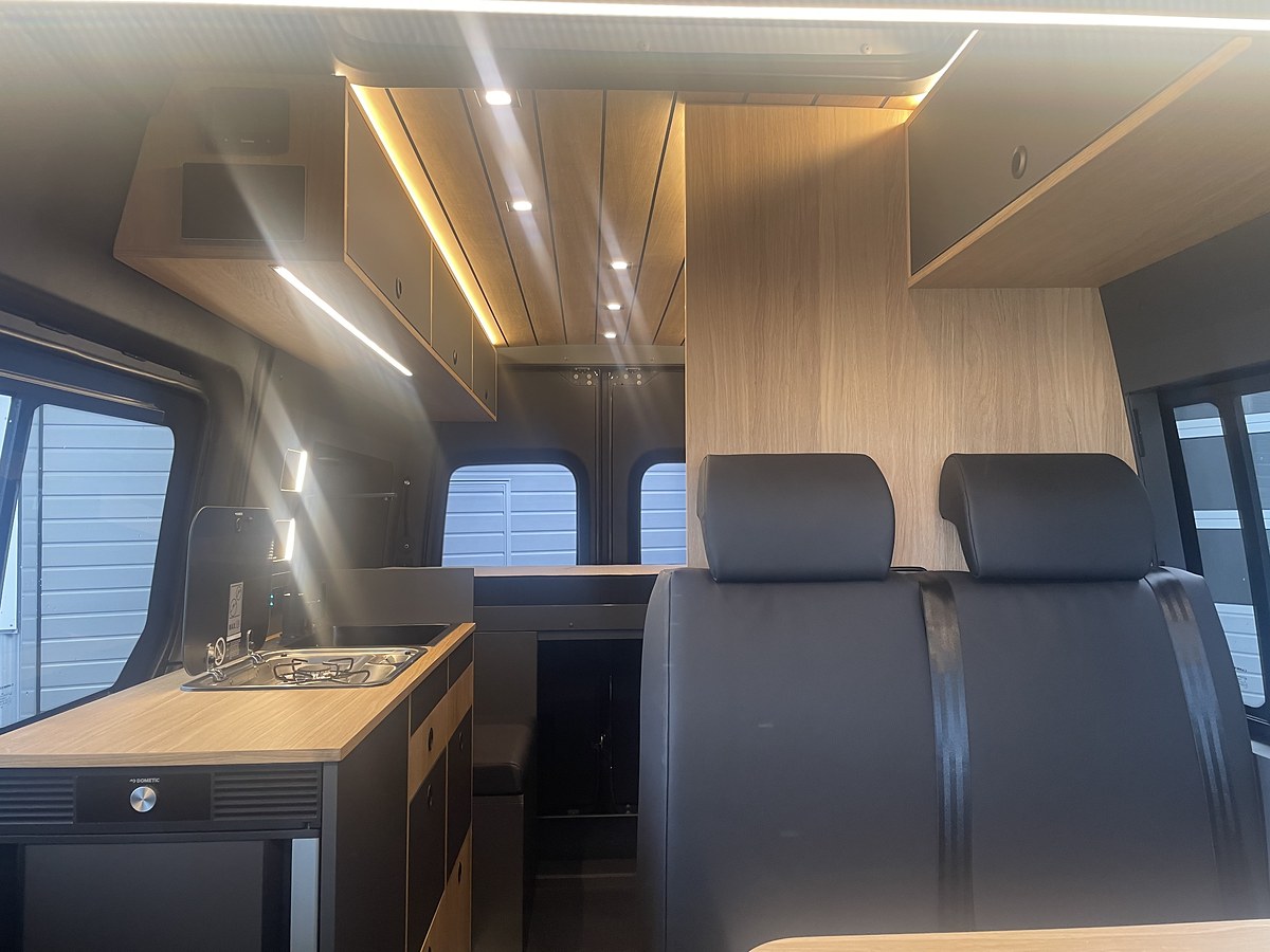 Sprinter mit Schlafdach, Mercedes Sprinter, Küche und Sitzgruppe mit dunklen Polstern